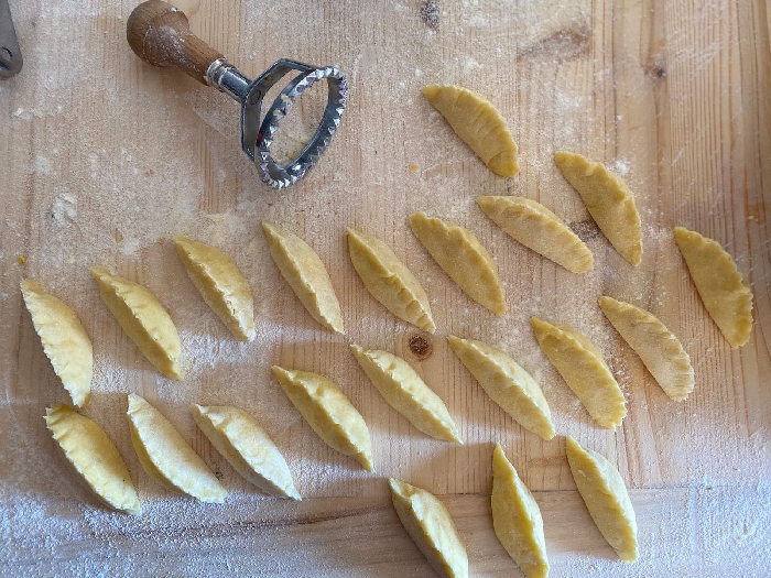 Gnocchi di patate farciti al pecorino, fave e guanciale, cipolla rossa salsa all'uovo arancia e tartufo nero