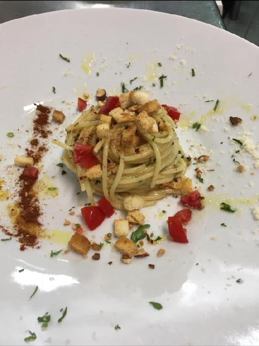 Spaghettoni aglio olio acciughe con crostini di pane cafone e pomodorini secchi, preparati dallo Chef Daniele Unione