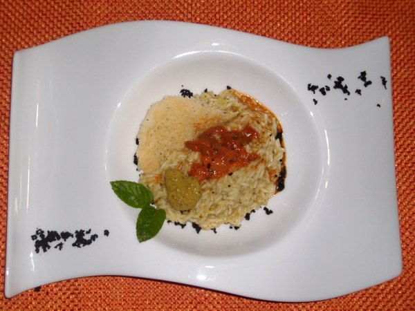 Risotto al pesto di pistacchio di Bronte con emulsione di uova di ricci e polvere di olive nere
