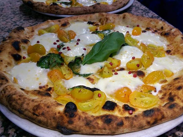 Pizza Sole mio (impasto s.t.g., pomodorino giallo del Vesuvio, mozzarella di bufala d.o.p., pepe rosa e olio extravergine d'oliva)